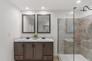 Primary bathroom with double vanity and walk-in shower inside a manufactured home sold by Northern Mobile Homes, a manufactured home dealer serving Vermont