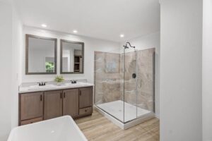 Luxury primary bathroom with double vanity and walk-in shower inside a manufactured home sold by Northern Mobile Homes, a manufactured home dealer in Rochester New Hampshire